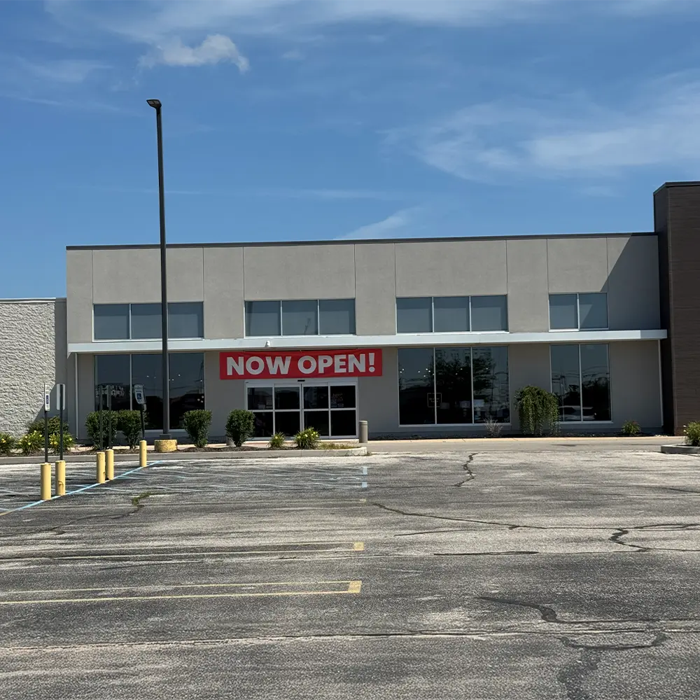 Exterior of the new ABC Warehouse Saginaw store at 2800 Tittabawassee Road featuring the main entrance and "Now Open!" banner with customer parking in front.