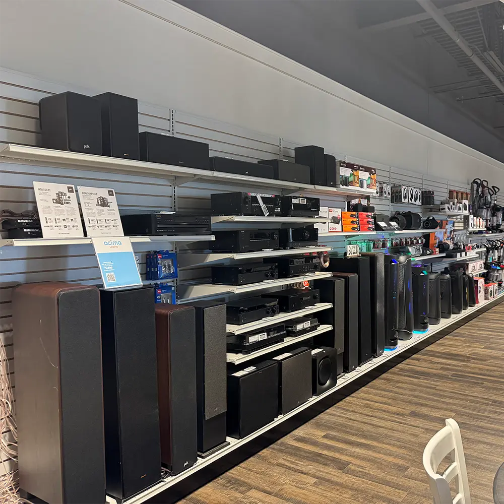 ABC Warehouse Saginaw home audio department featuring soundbars, speakers, subwoofers, stereo receivers, headphones, and home theater accessories on display.